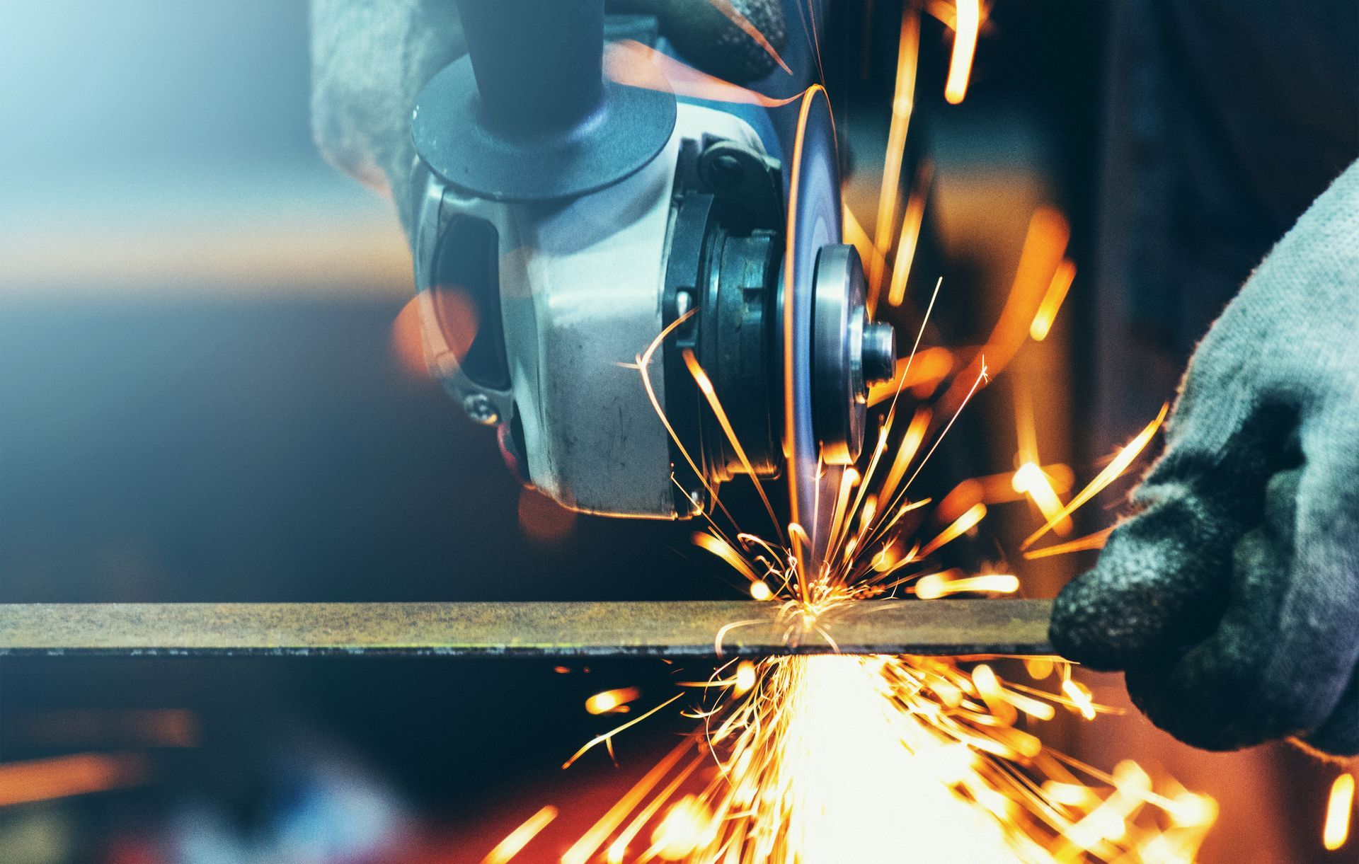 Closeup of metal being cut by an expert with flying sparks.