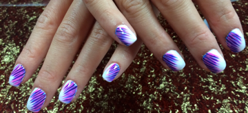 Hands with white and purple nail polish art.