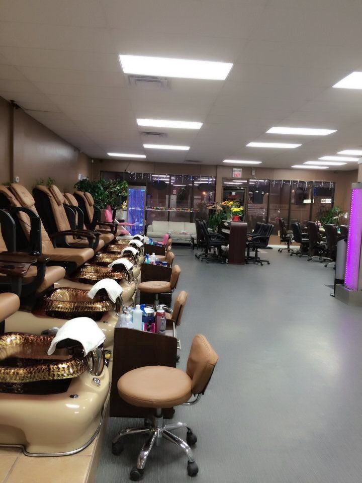 Nail salon interior with pedicure chairs, manicure stations, and a wide, open space.
