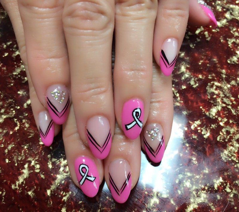 Pink nails with white breast cancer ribbons and black accents.