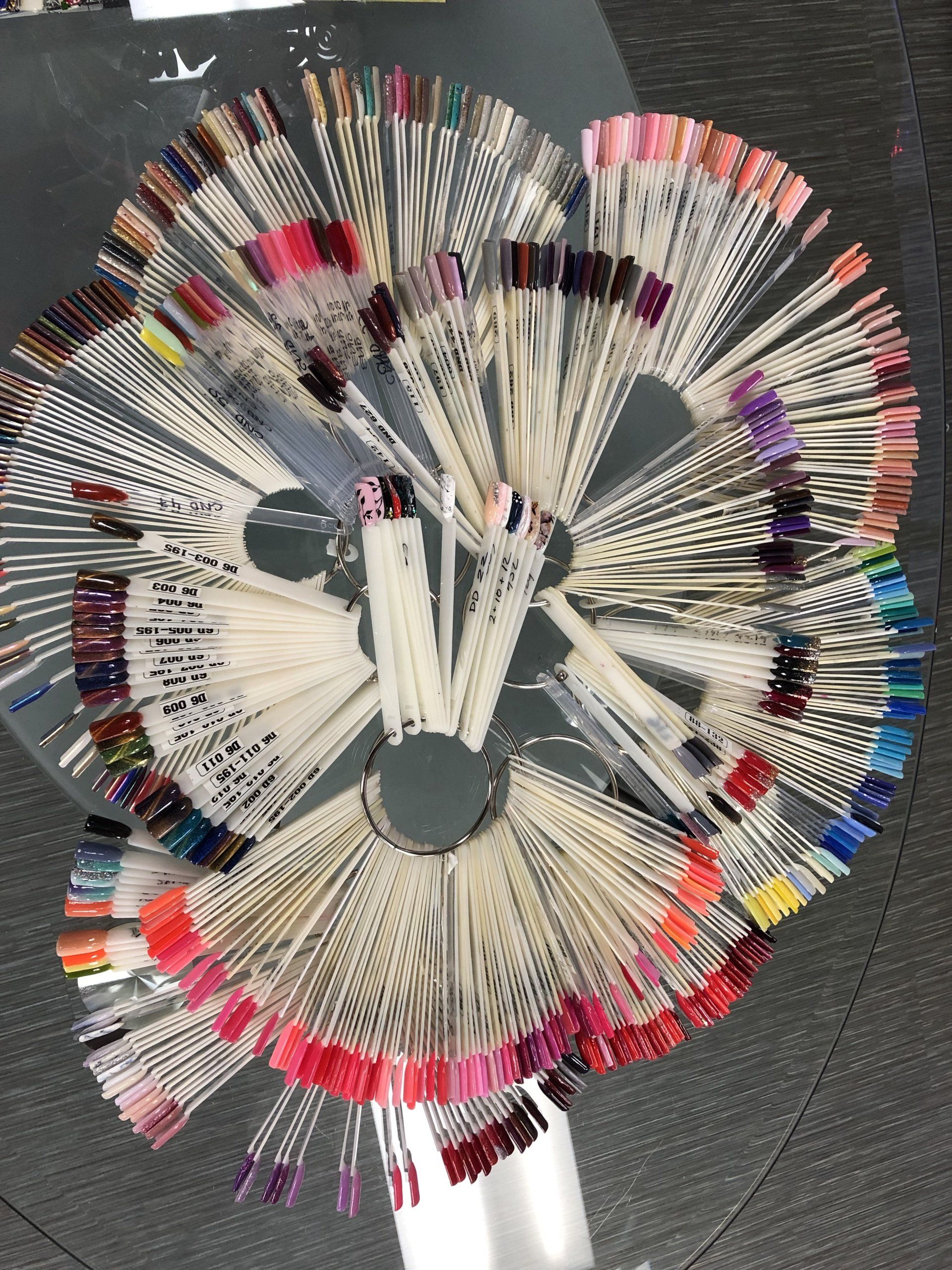 Nail polish color samples on display, arranged in a fan shape, offering a variety of shades.