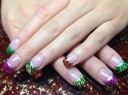 Hands with French-tip nails; colorful zebra print tips with silver outlines.