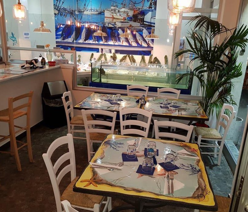 Un ristorante con tavoli e sedie e un dipinto sul muro