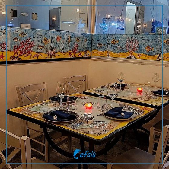 Un ristorante con tavoli e sedie e un cartello che dice cefali