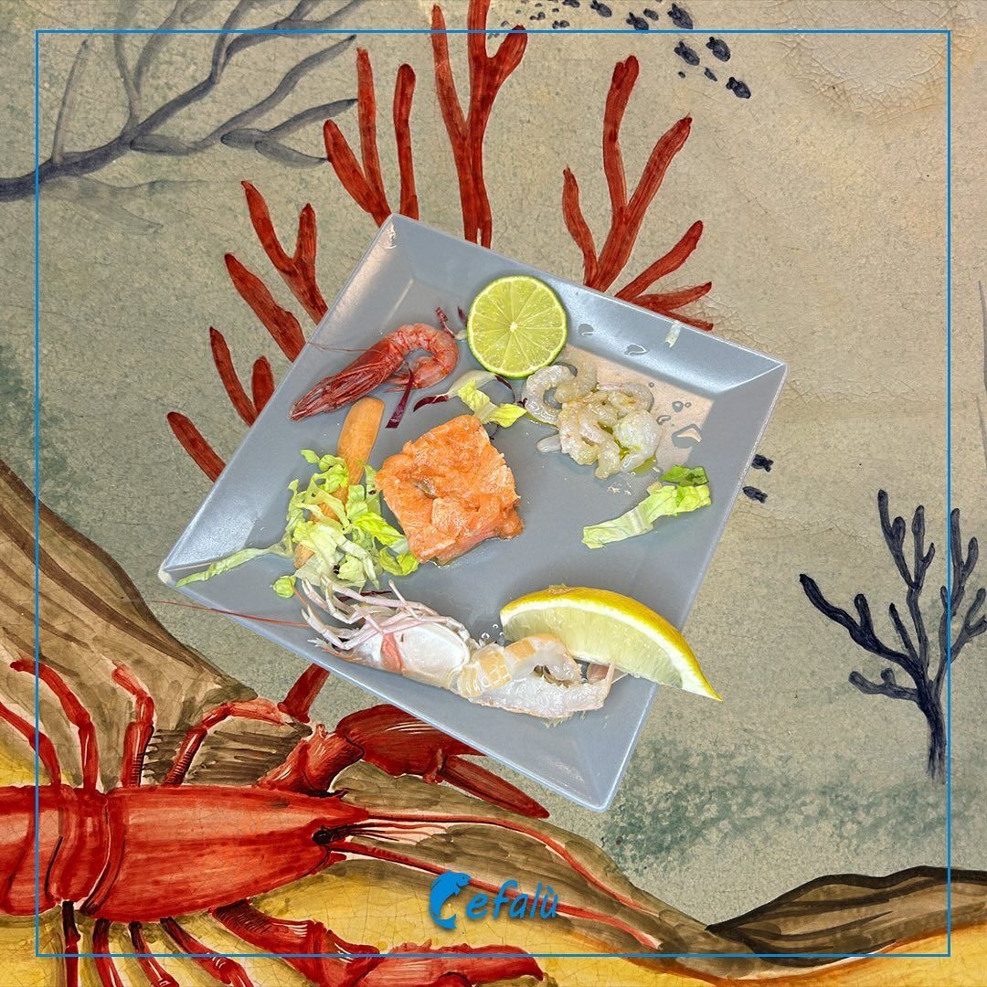 Un piatto di cibo con un'aragosta sullo sfondo