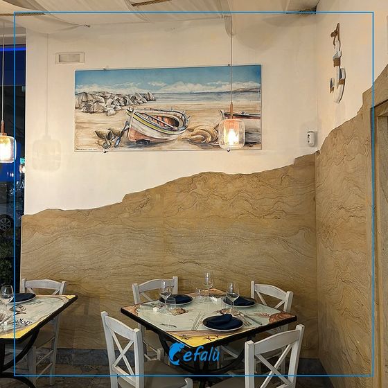 Un ristorante con tavoli e sedie e un dipinto sul muro