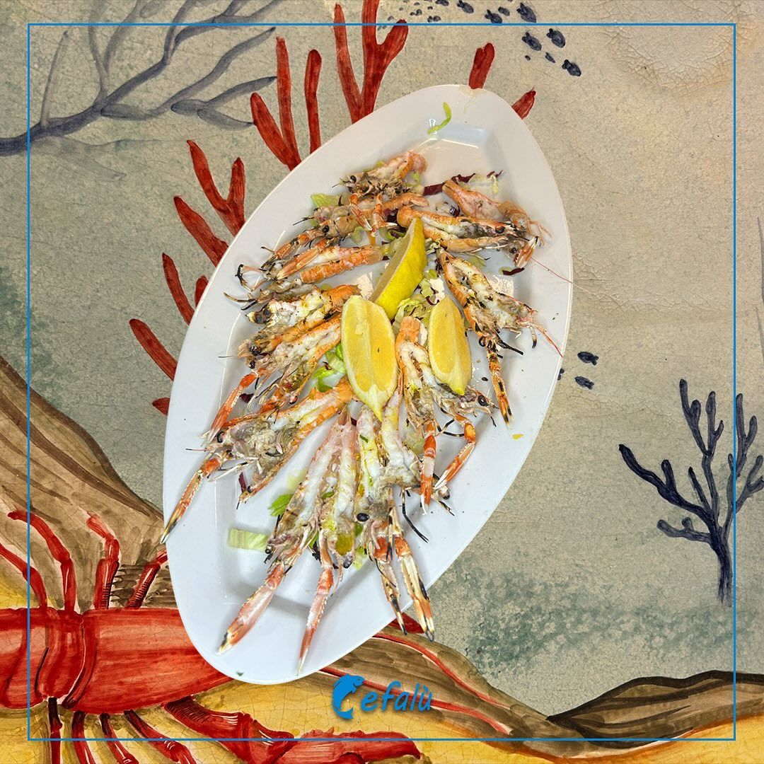 Un piatto di cibo con un'aragosta sullo sfondo