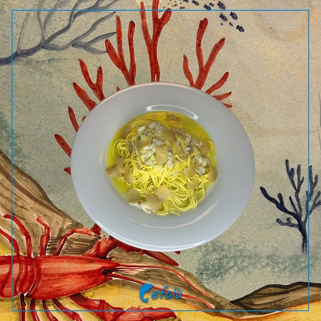 Una ciotola di noodles con un'aragosta sullo sfondo