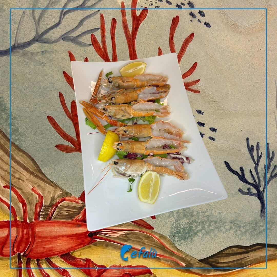 Un piatto di cibo con un'aragosta sullo sfondo