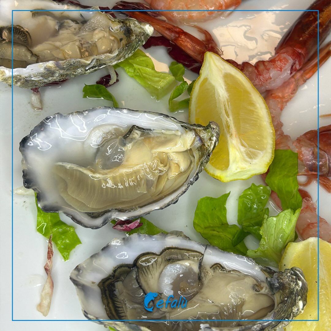 Tre ostriche sono su un piatto con fette di limone e lattuga