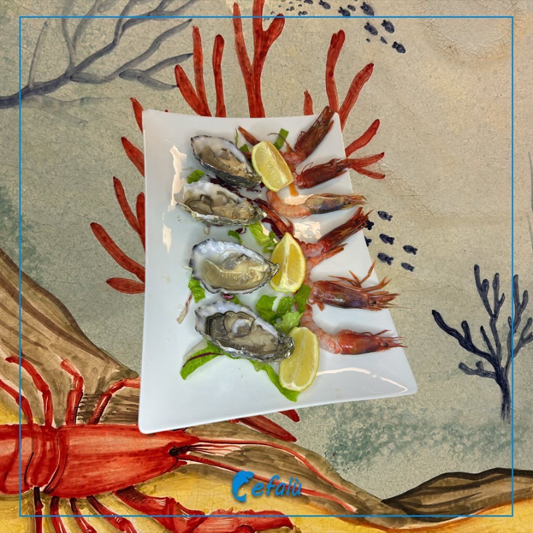 Un piatto bianco guarnito con ostriche e gamberi