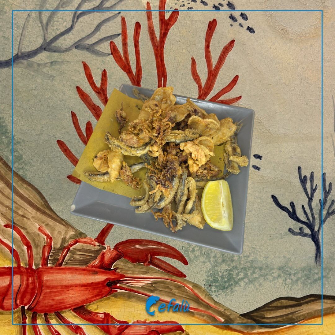 Un piatto di cibo con un granchio e un limone sopra