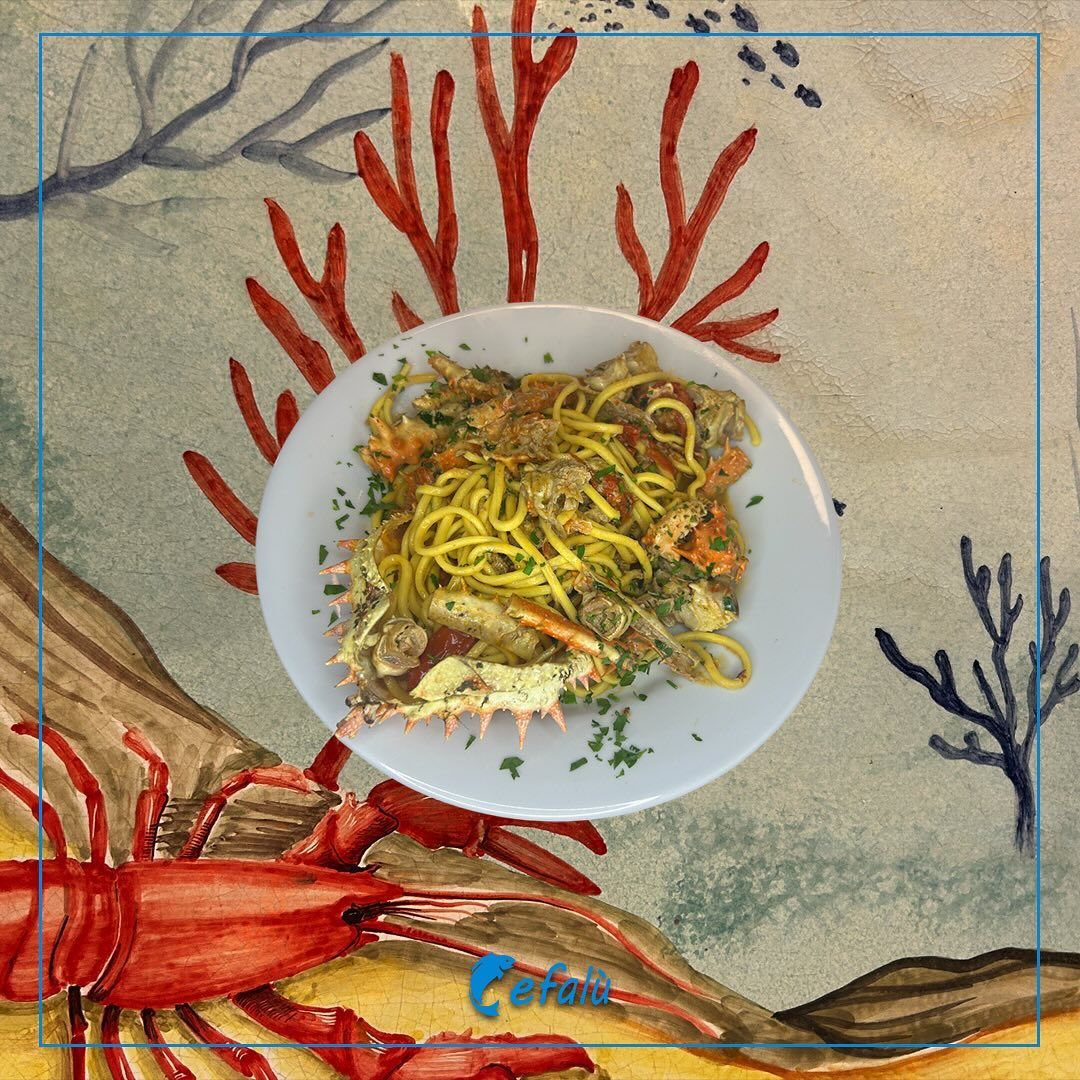 Un piatto di cibo con un'aragosta sullo sfondo