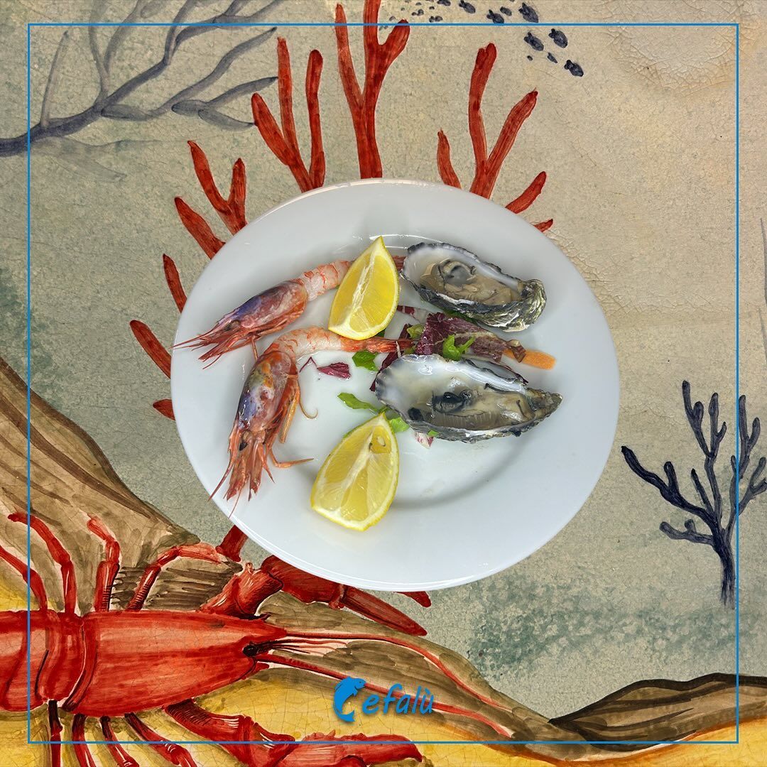 Un piatto di frutti di mare con un'aragosta sullo sfondo