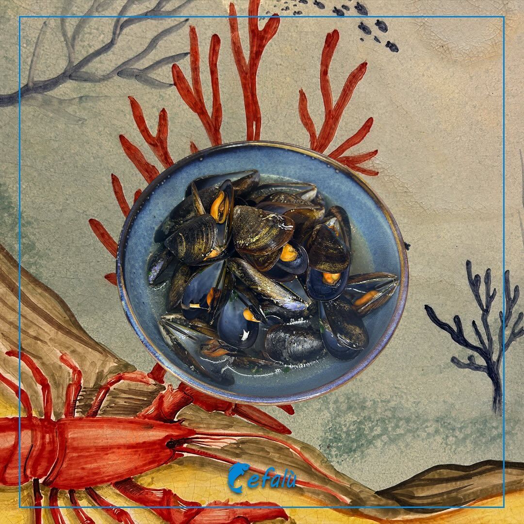 Un dipinto di un'aragosta e una ciotola di cozze