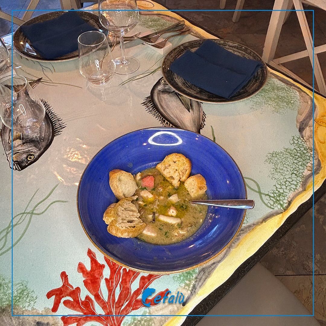 Una ciotola blu di zuppa è appoggiata su un tavolo