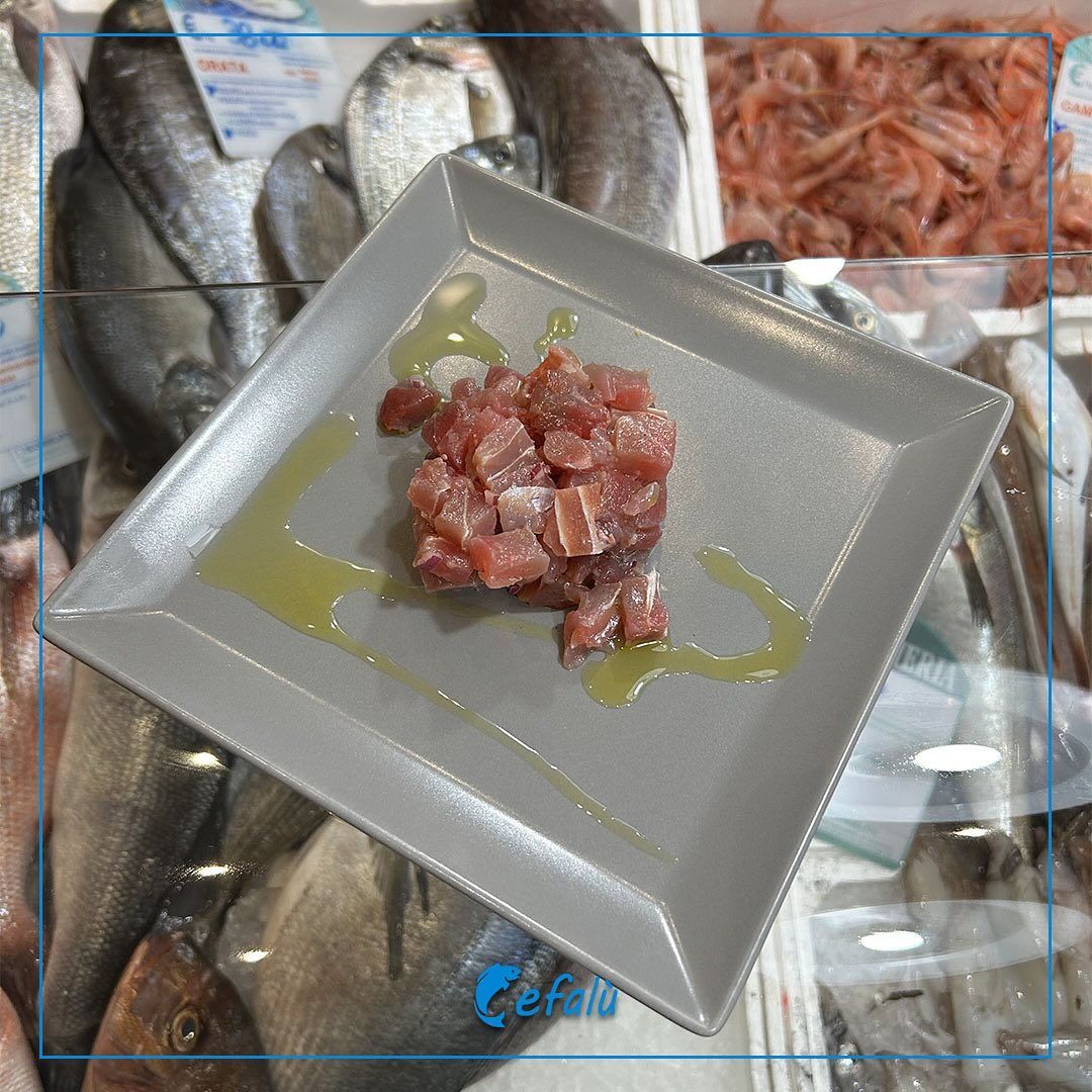 Un piatto quadrato con carne e olio d'oliva sopra