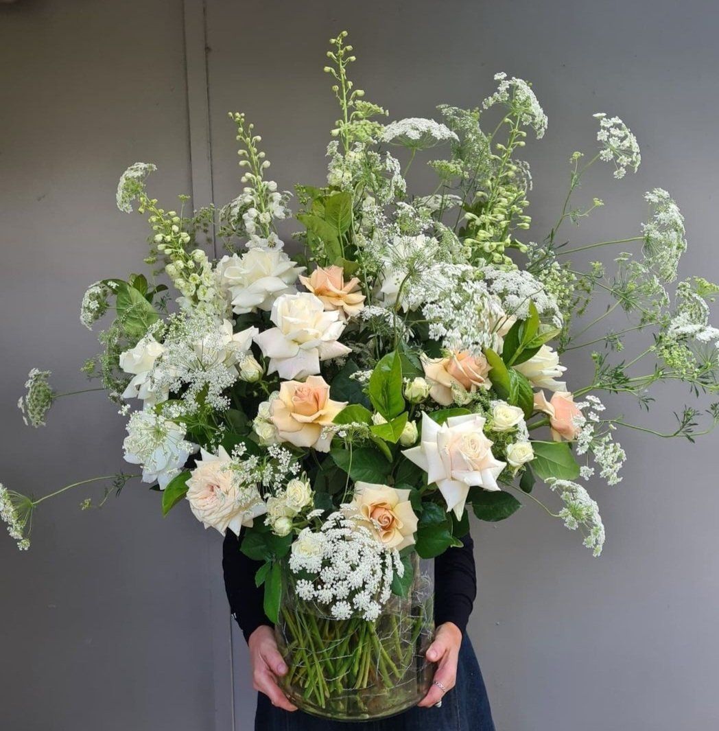 a person is holding a vase filled with flowers .