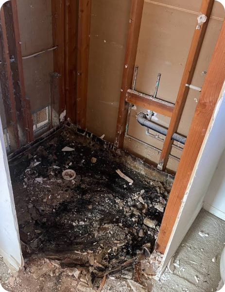 A bathroom with a lot of trash on the floor and walls.