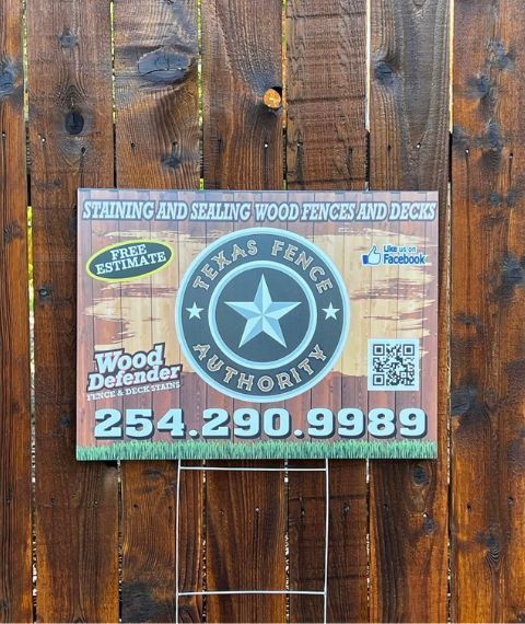 A texas fence authority sign on a wooden fence