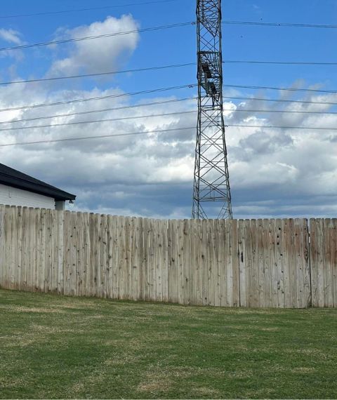A wooden fence with a telephone pole in the background