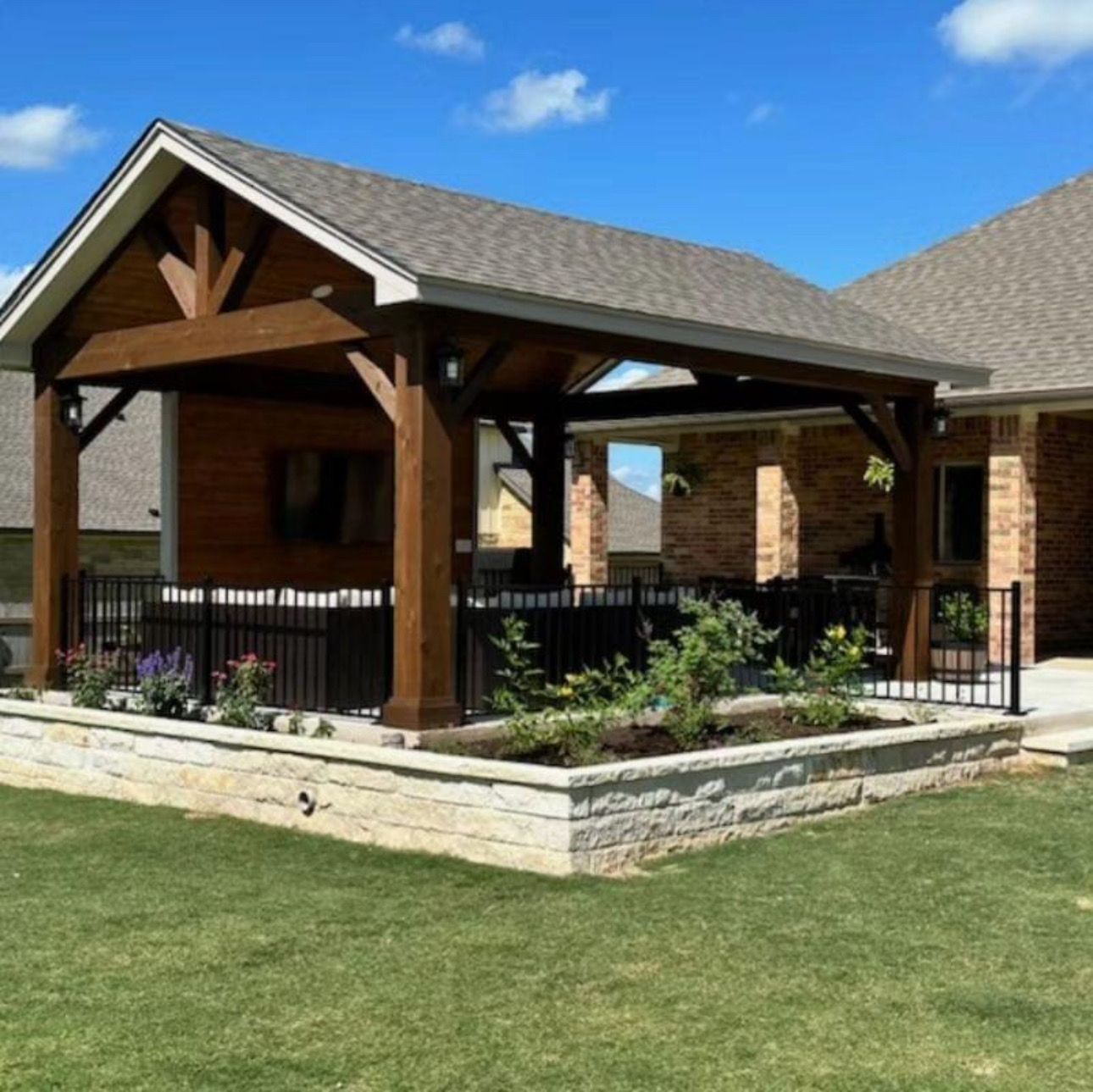 A brick house with a wooden gazebo in front of it
