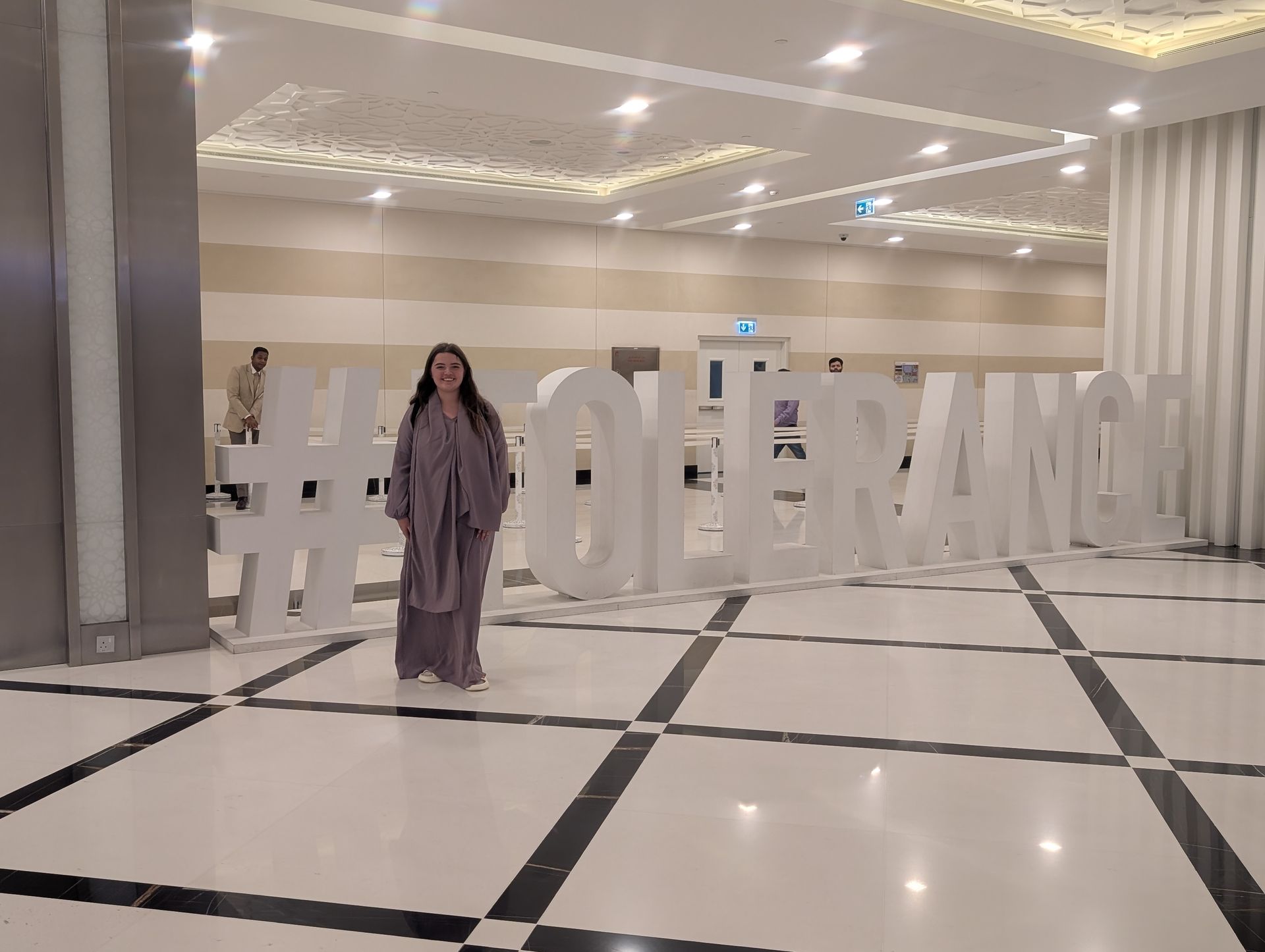 Woman stands in front of a white 