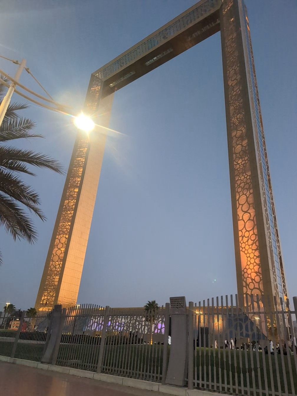 The Dubai Frame stands against a twilight sky; ornate gold-colored frame structure.