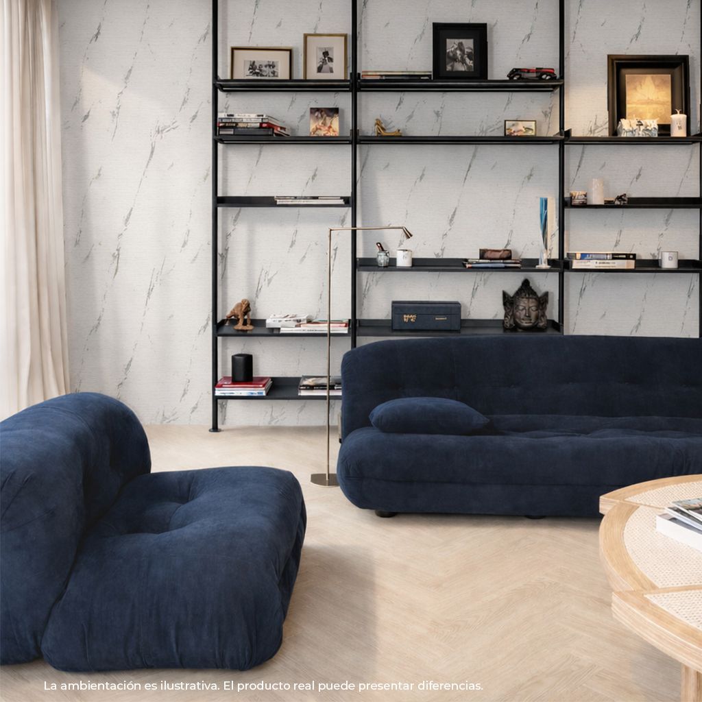 Sala de estar moderna con sofás azul marino, estanterías negras y decoración minimalista sobre una pared clara.