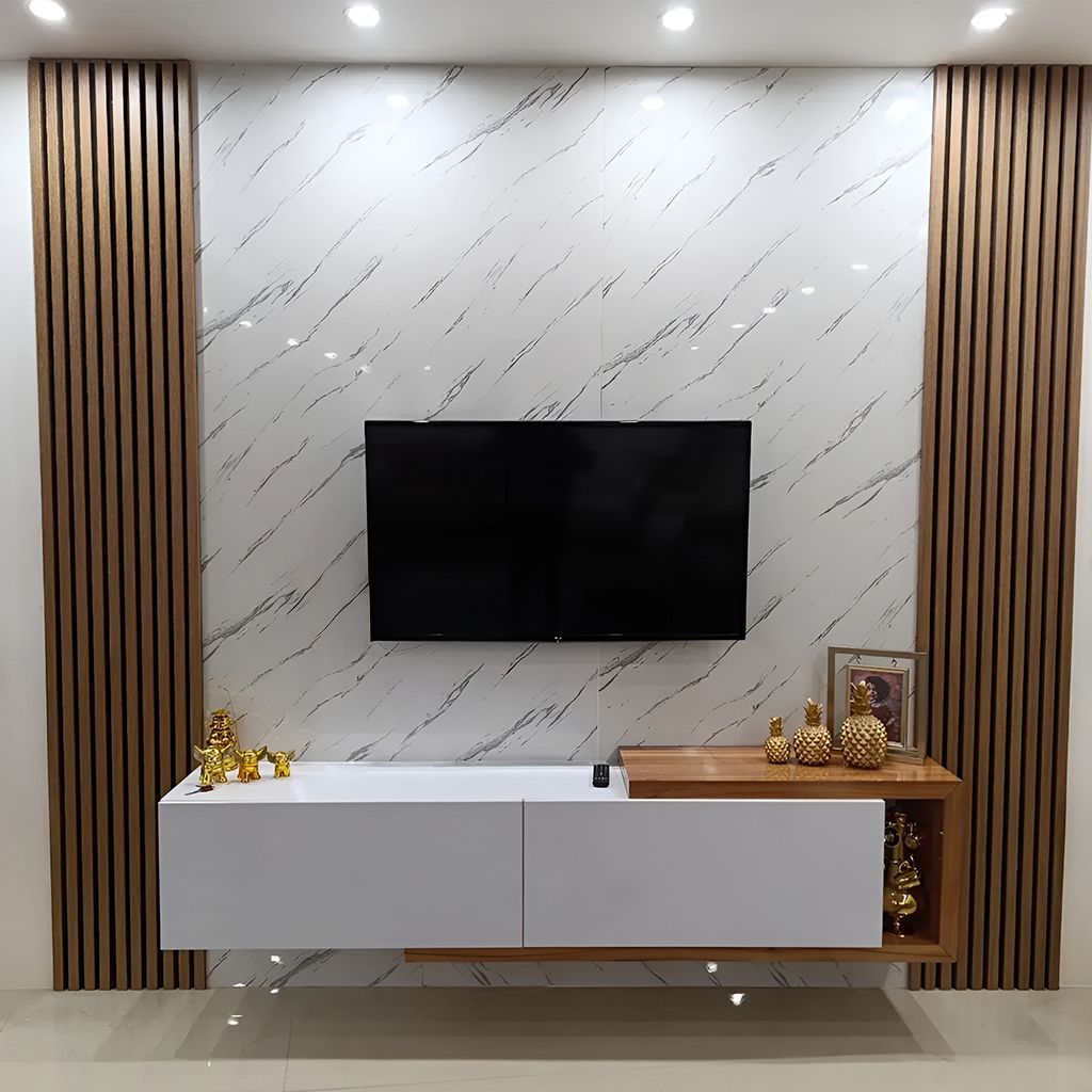 Pared de sala de estar moderna con televisor montado, revestimiento de mármol blanco y detalles de listones de madera.