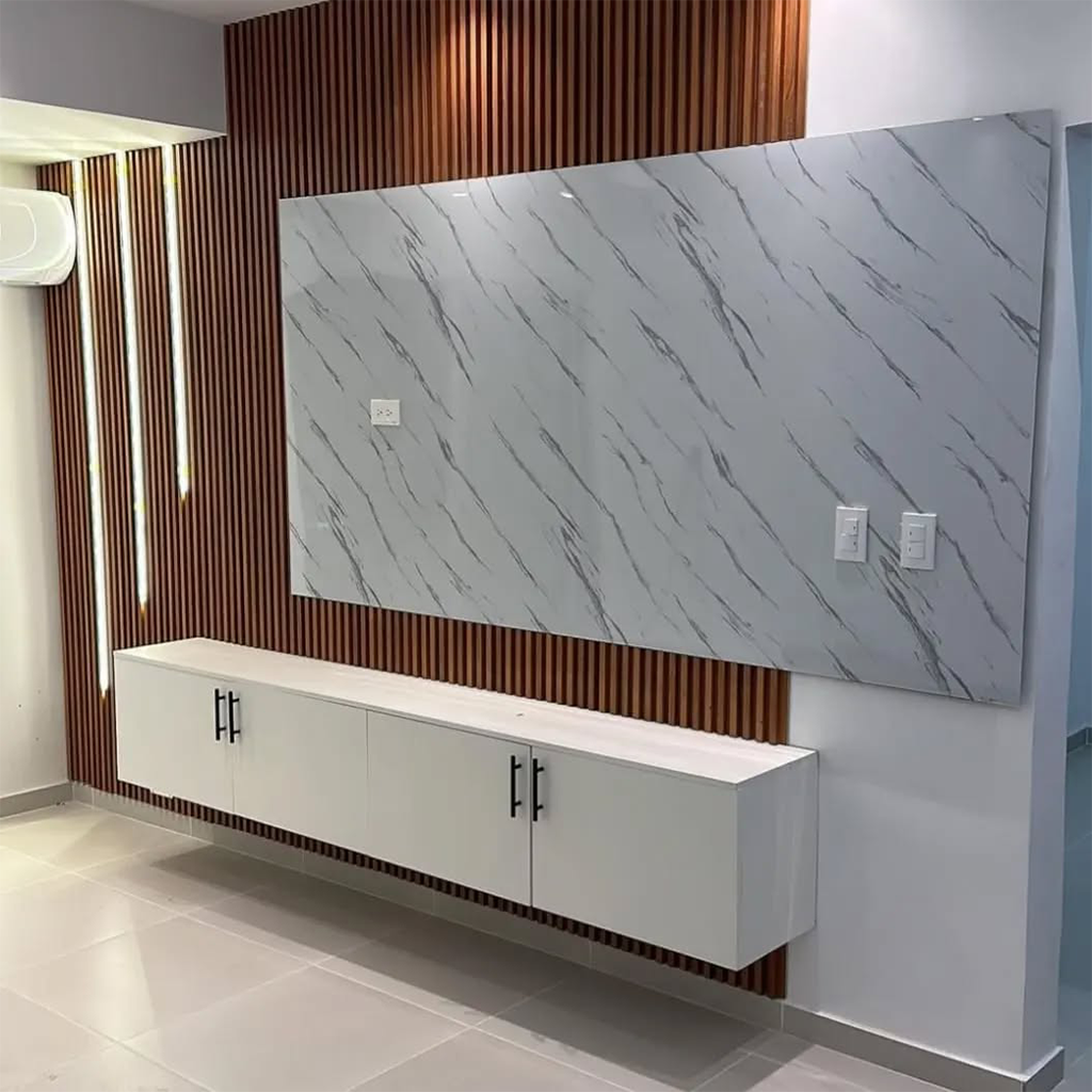 Pared de sala de estar moderna con televisor montado, revestimiento de mármol blanco y detalles de listones de madera.