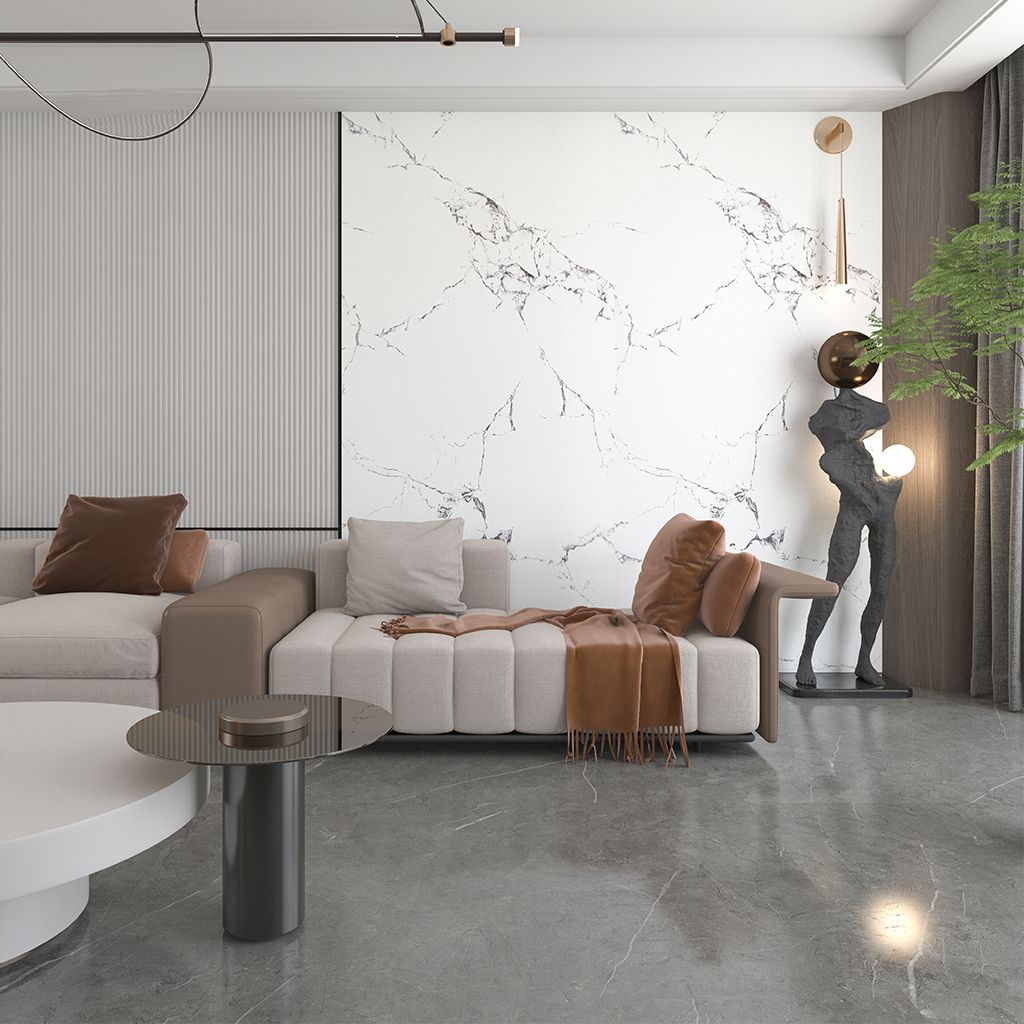 Sala de estar moderna con sofá modular beige, pared decorativa de mármol, suelo gris e iluminación con estatuas decorativas.