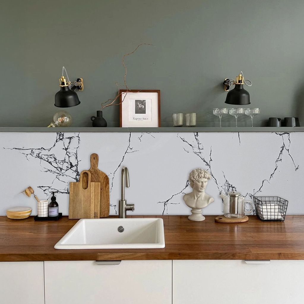 Sala de estar moderna con sofá modular beige, pared decorativa de mármol, suelo gris e iluminación con estatuas decorativas.