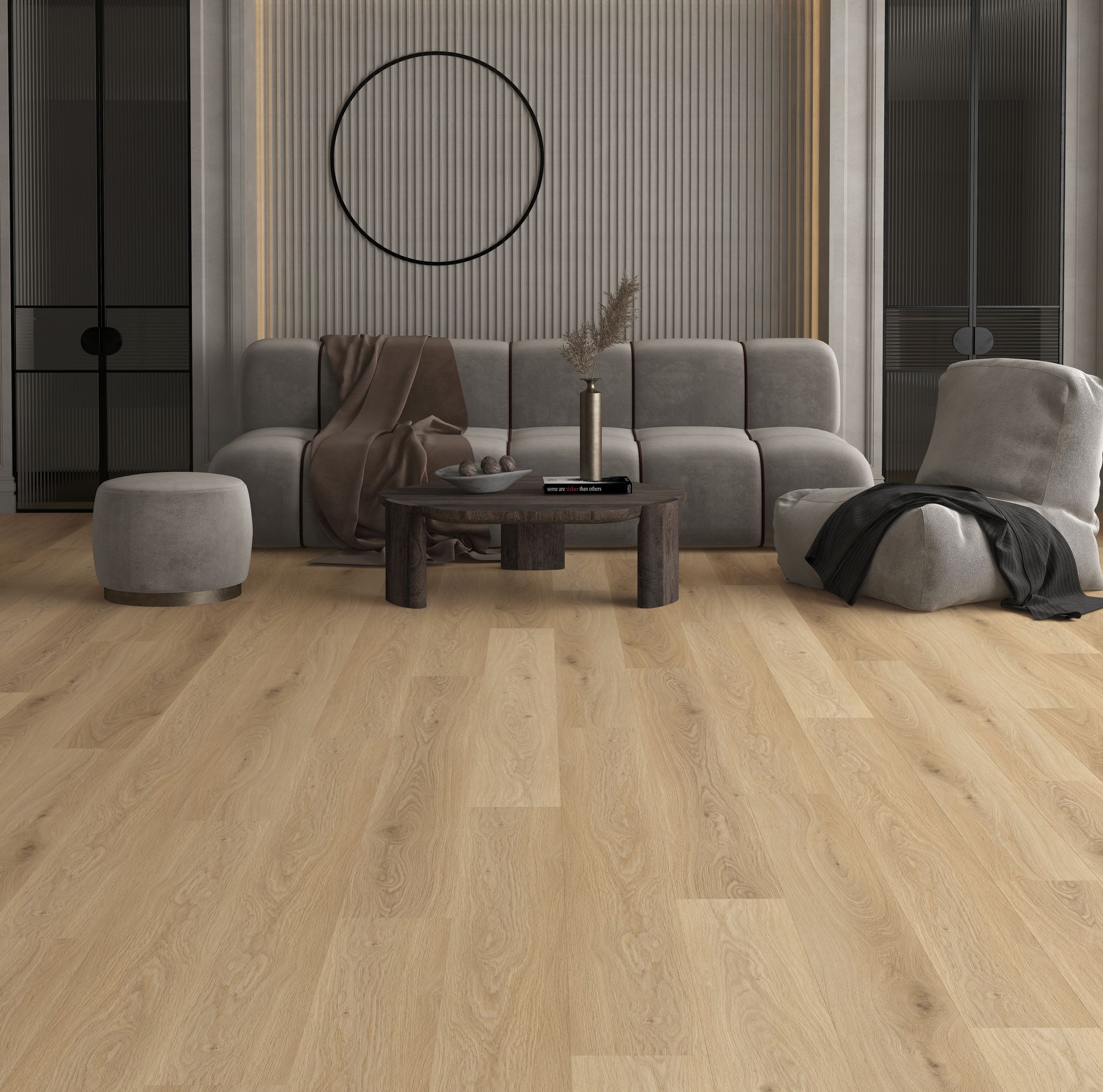 Sala de estar moderna con sofá gris, cuadro redondo en la pared, otomana, mesa de centro y suelo de madera clara.
