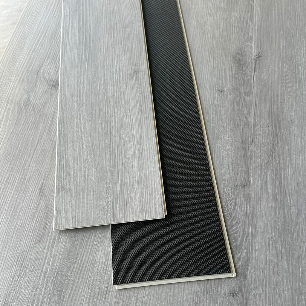 Sala de estar moderna y minimalista con un sofá seccional gris, una mesa de centro redonda y suelo de madera clara.