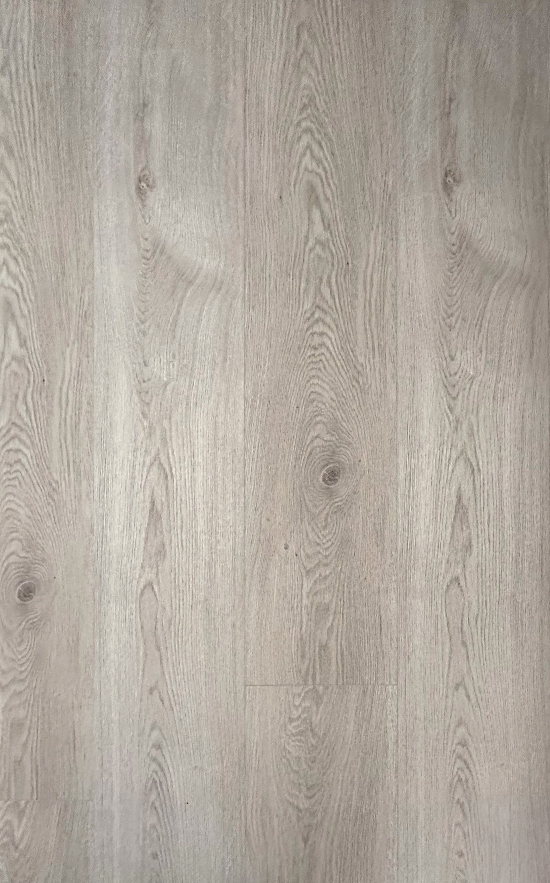 Vestíbulo de hotel moderno con altas columnas, suelo de madera gris y zonas de estar en tonos naranja y verde.