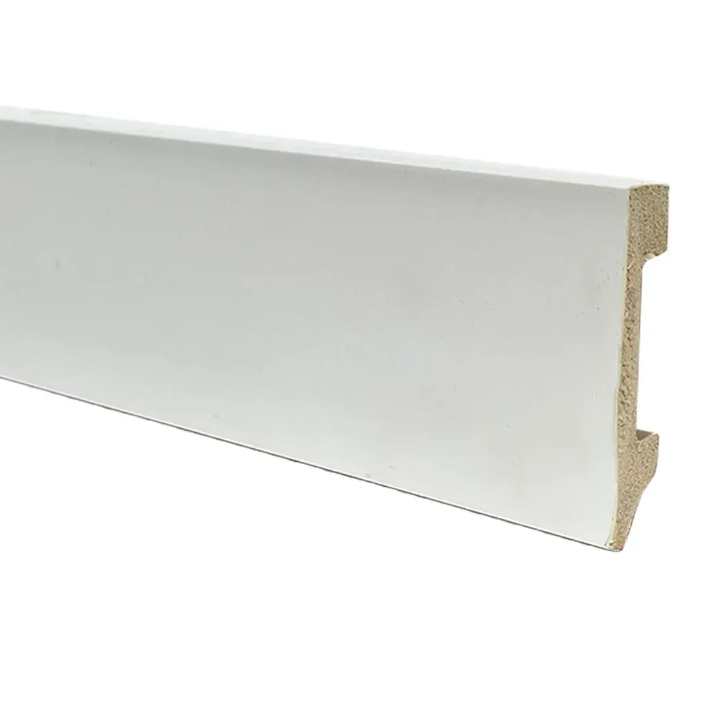 Sala de estar minimalista con silla estampada, manta blanca y negra sobre una superficie, planta y libros en el alféizar de la ventana.