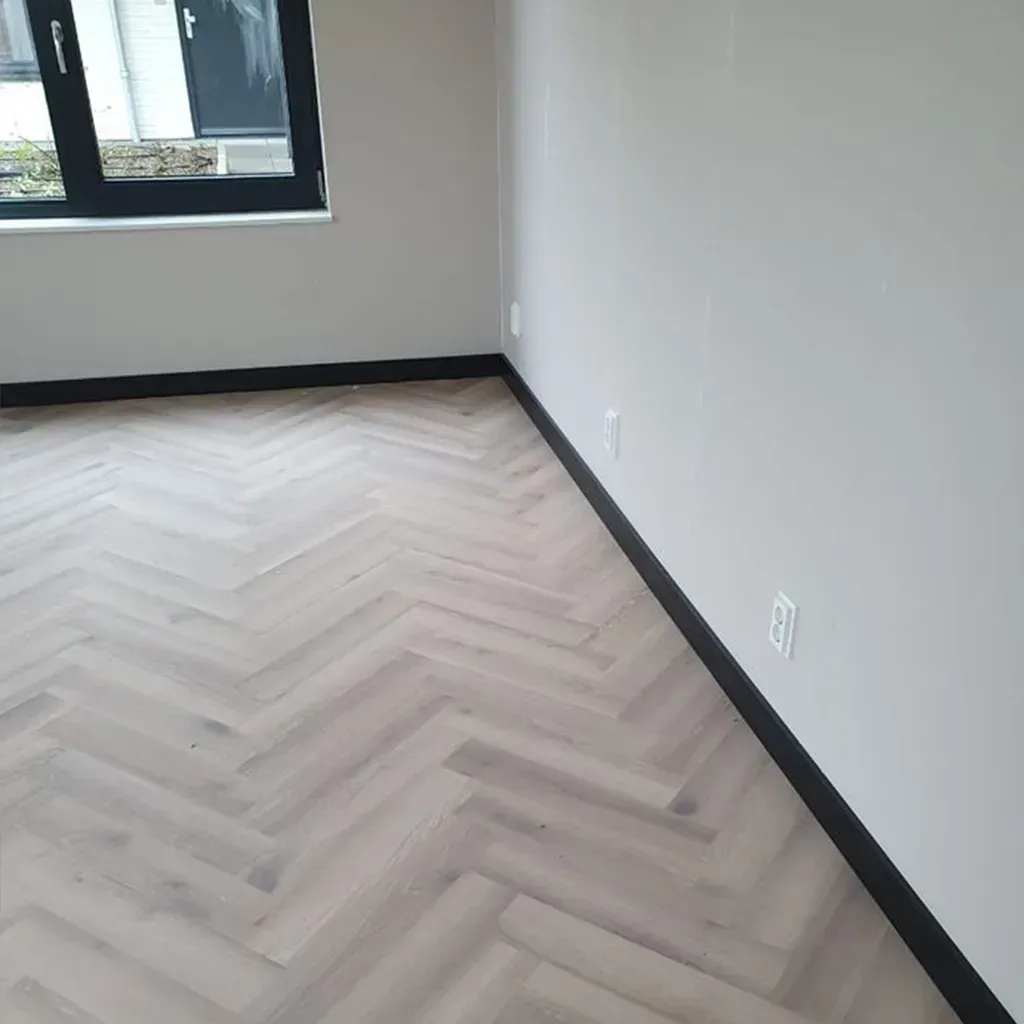 Moldura decorativa de metal negro con borde ranurado, mostrada sobre un fondo blanco.