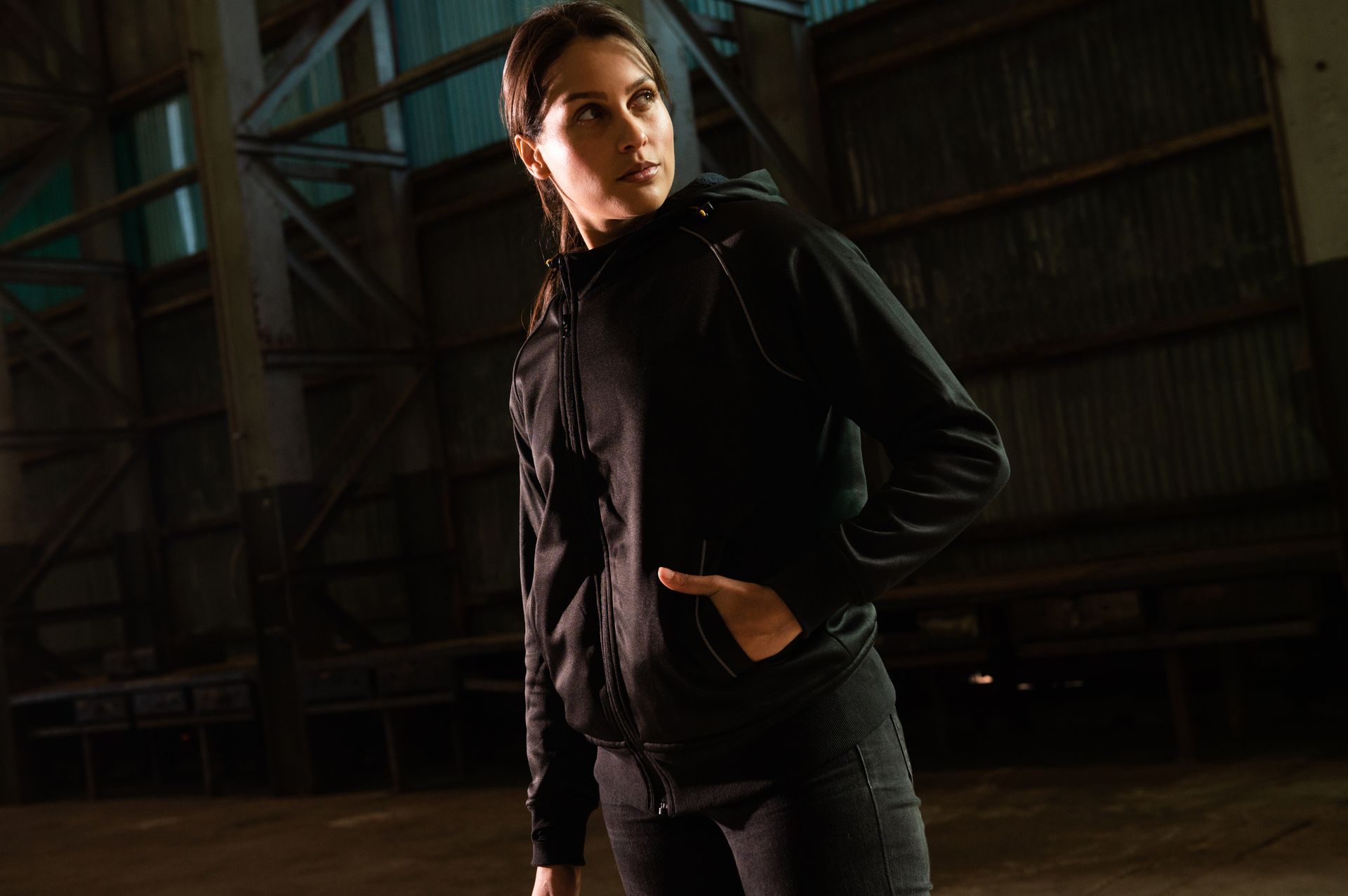 a woman at a worksite wearing  a black reflective hoody and pants as trendy and comfortable workwear