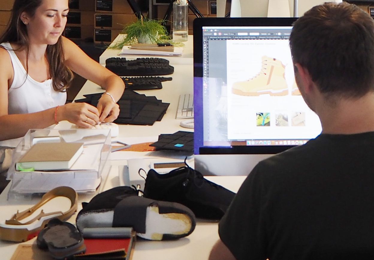 a footwear designer working on CAD and holding prototype of a new anti-fatigue sole of a safety boo