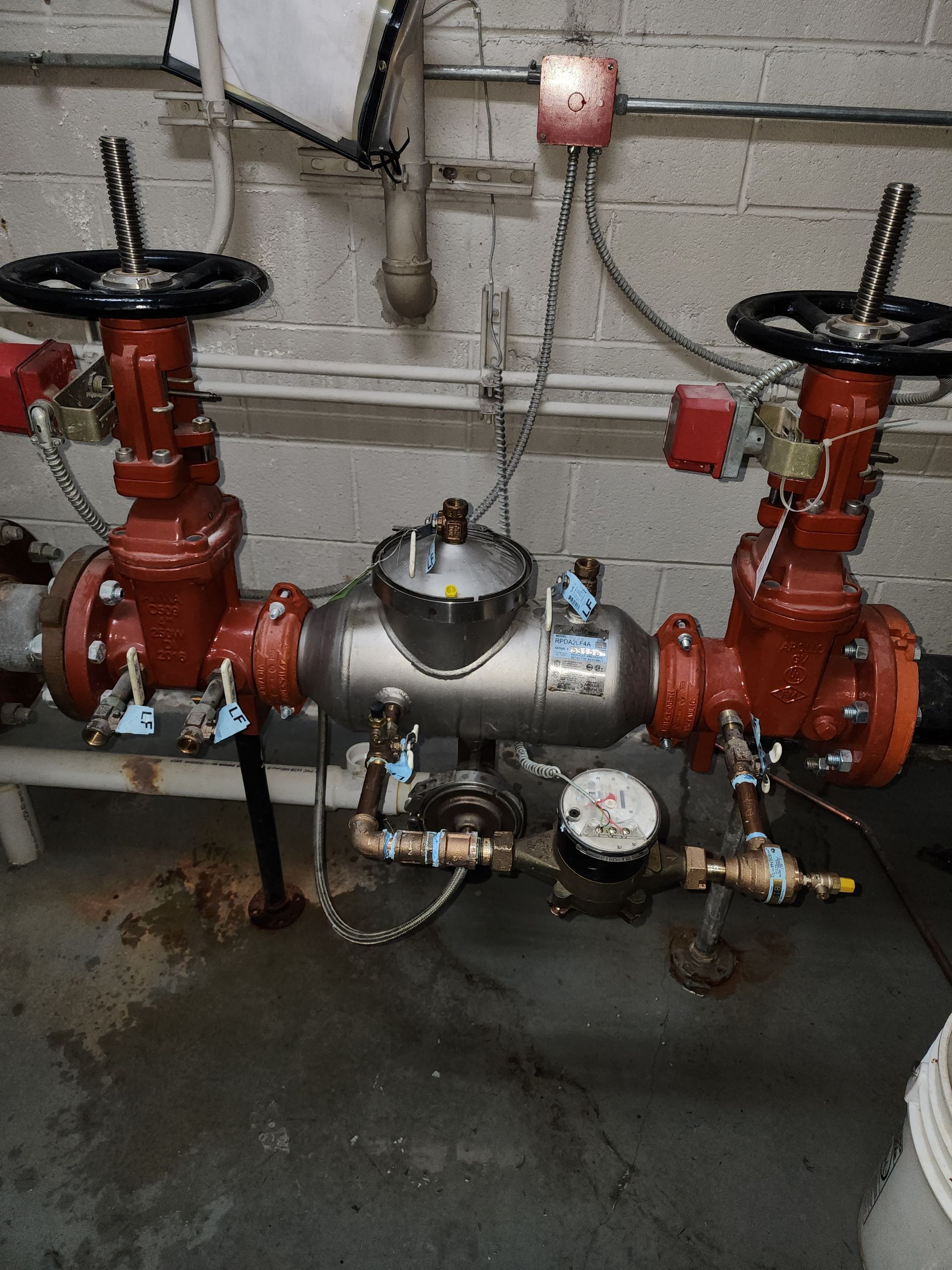 a bunch of pipes and valves are sitting on the floor in a room .