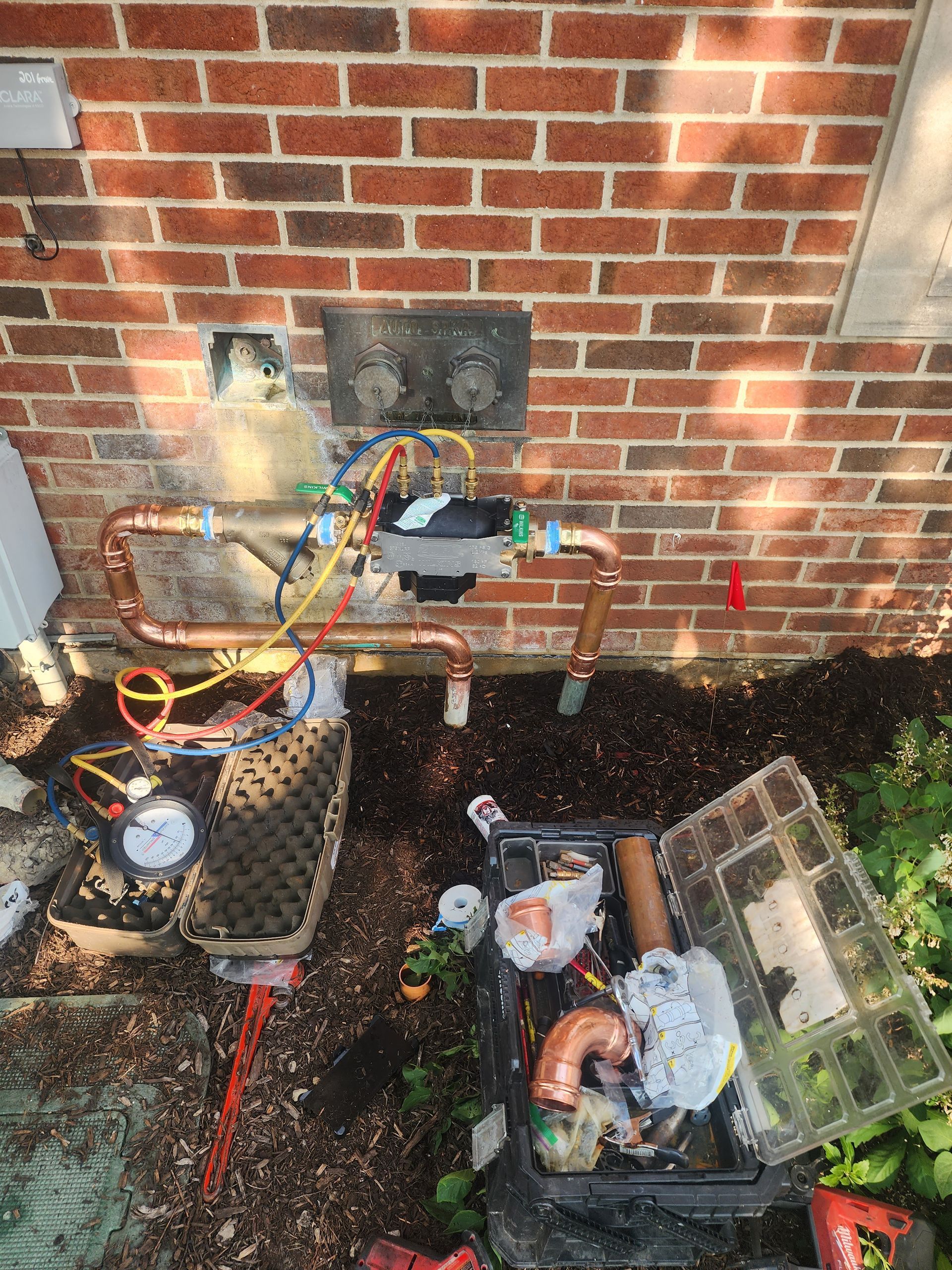 a brick wall with a bunch of pipes coming out of it .