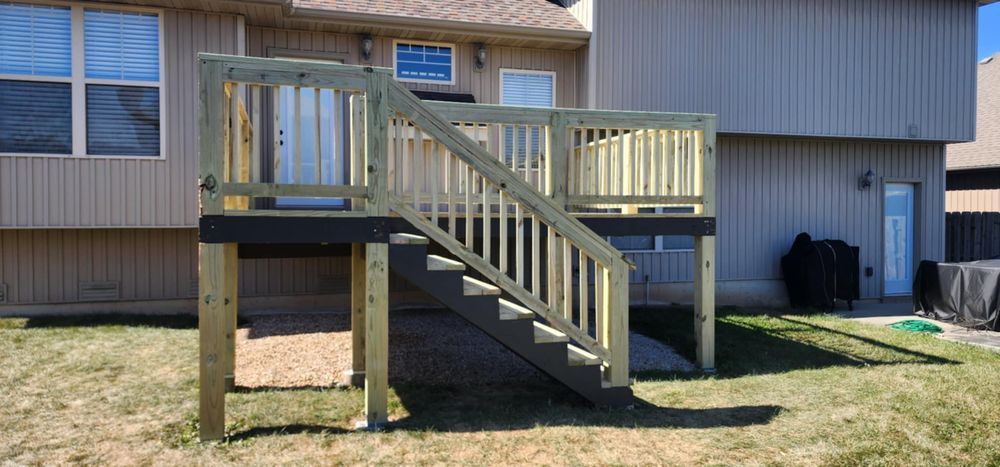 A wooden deck with stairs in front of a house