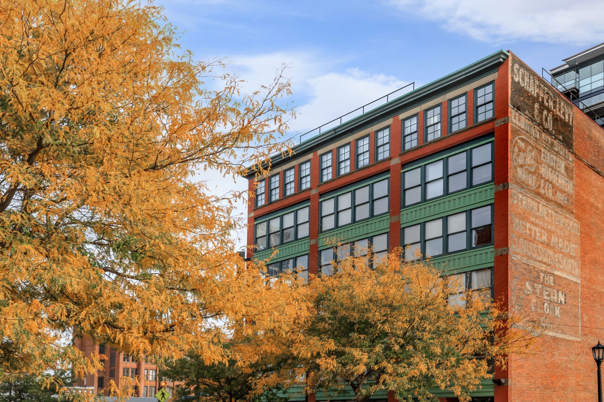 A large brick building with a lot of windows and a tree in front of it.