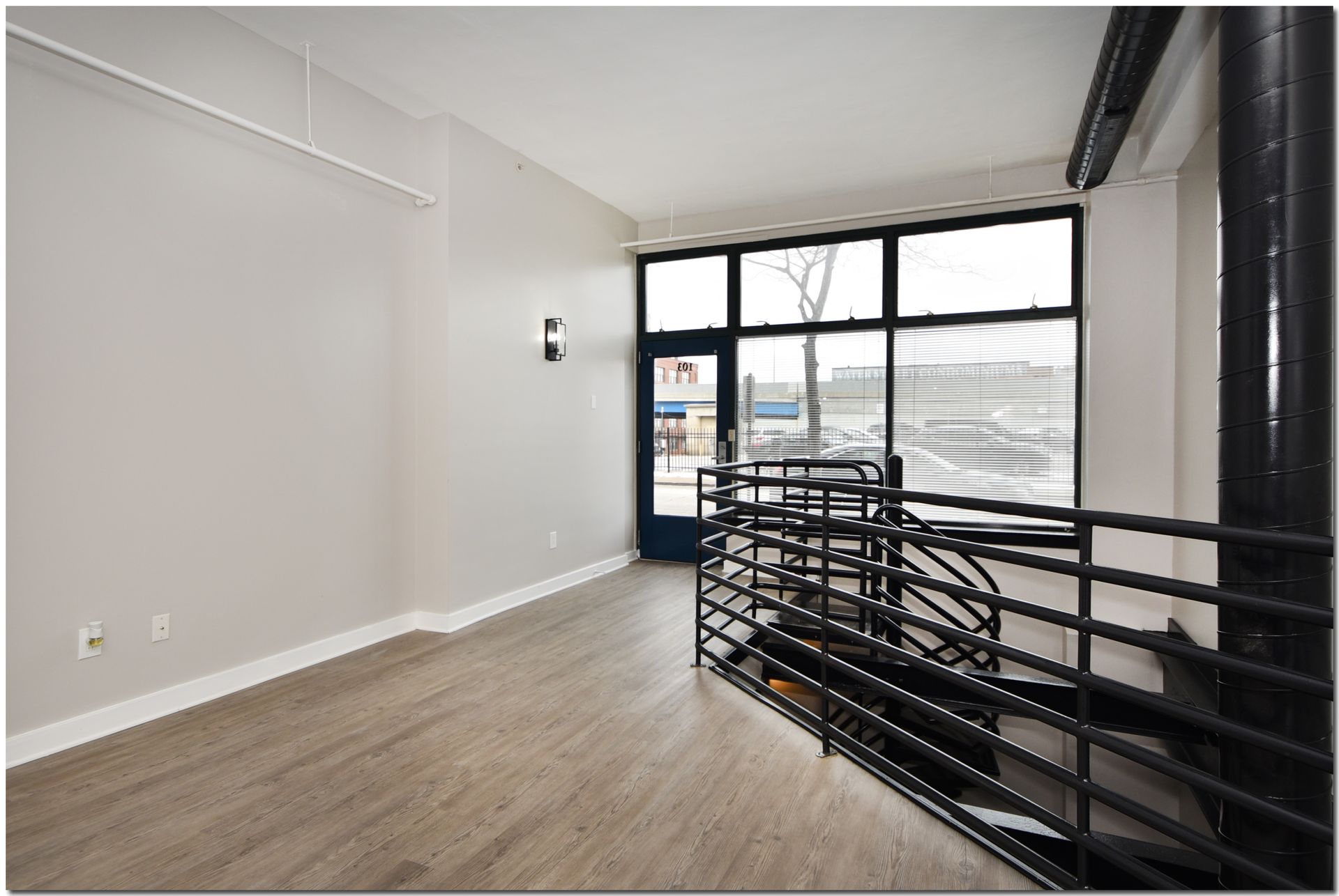 An empty room with a staircase and a large window