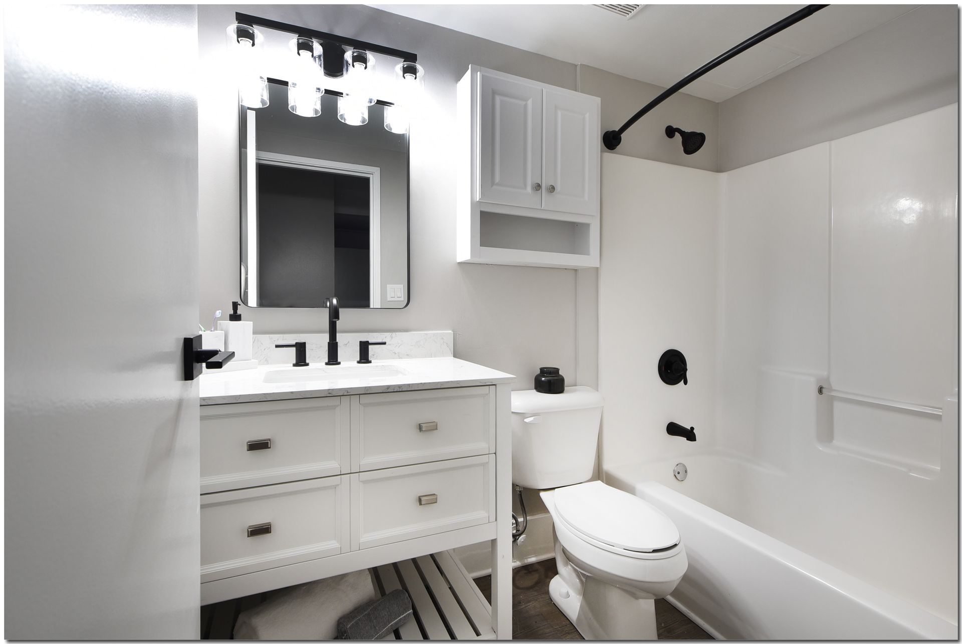 A bathroom with a toilet , sink , mirror and bathtub