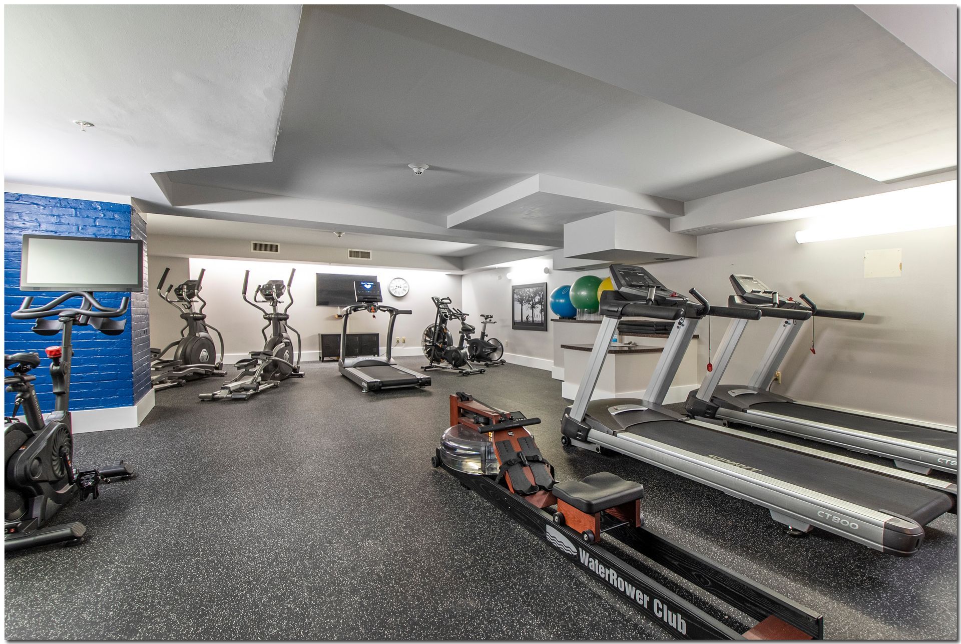 A gym with a lot of treadmills and bikes