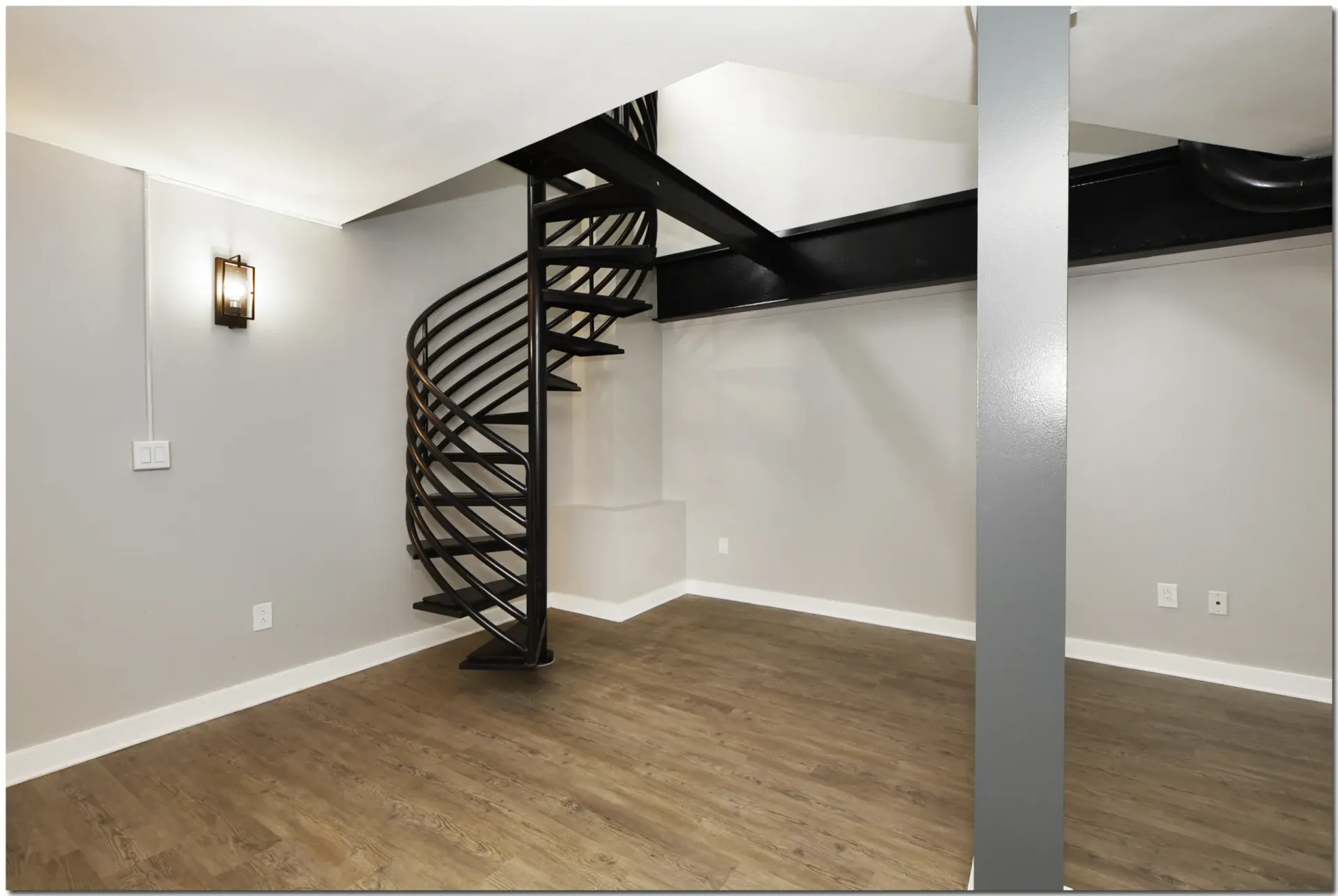An empty room with a spiral staircase in the corner
