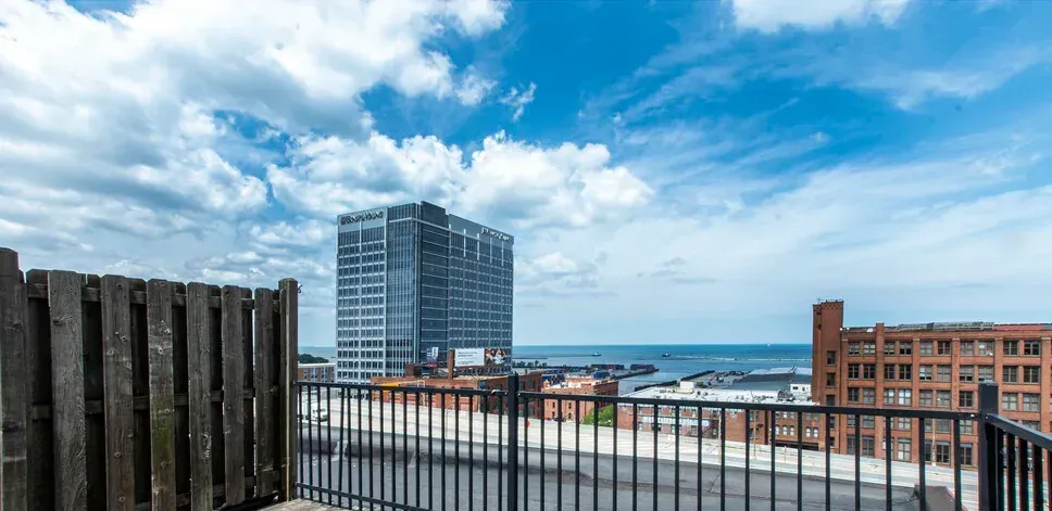 A balcony with a view of a city and the ocean.