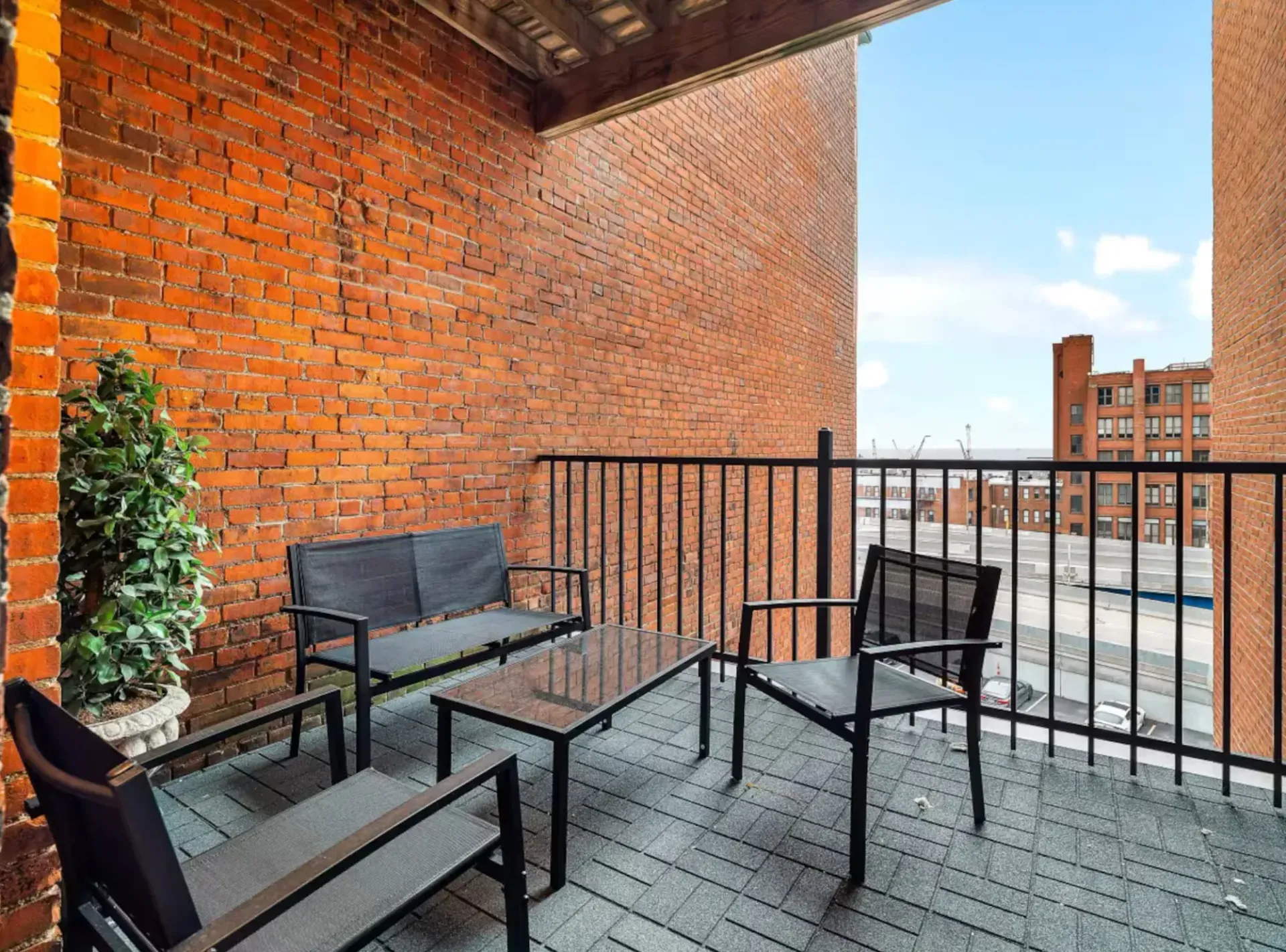 There is a balcony with a couch and chairs on it.